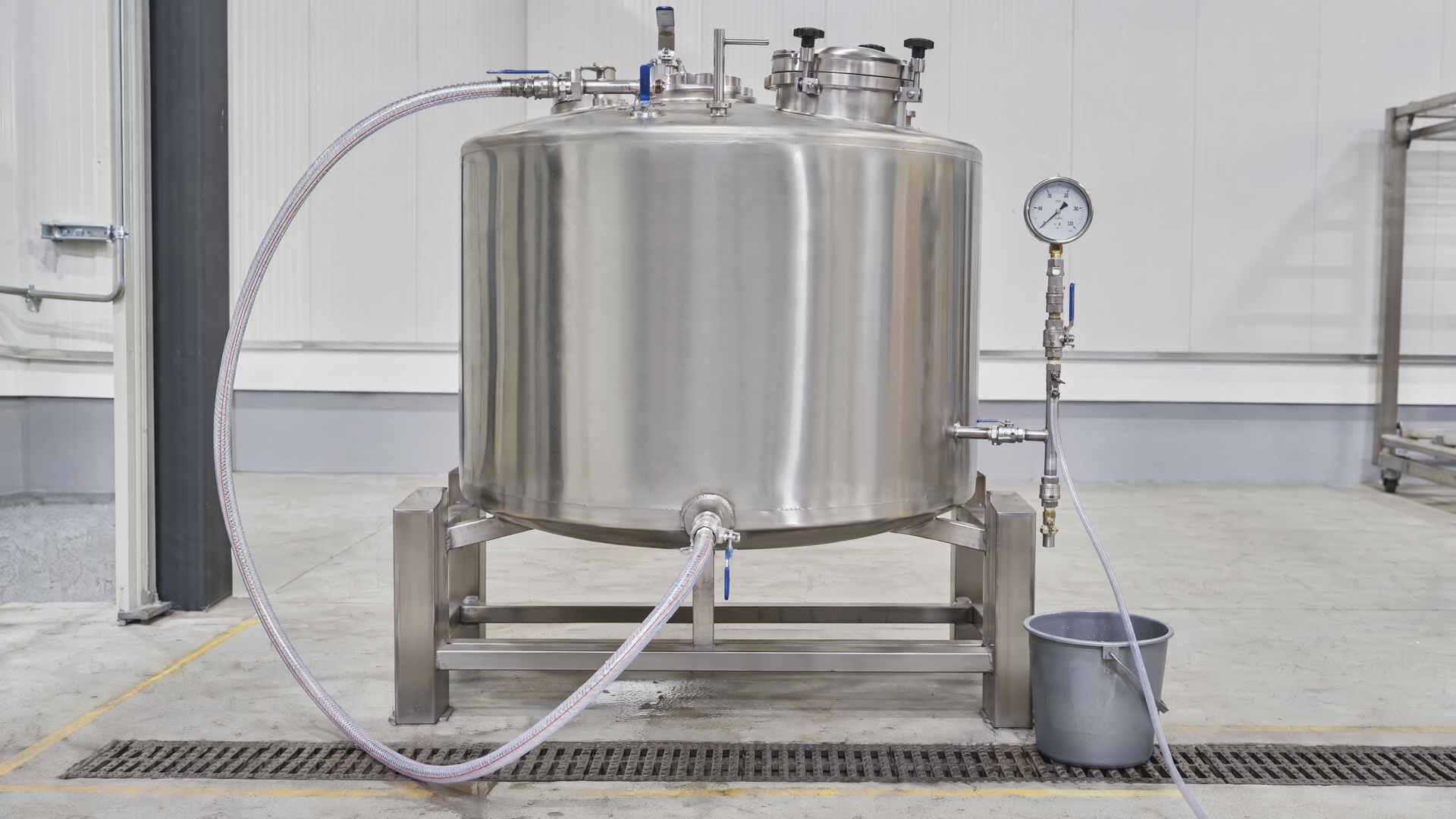 Controlled tank-body hydrostatic water-test setup with generic gauge and connected hose